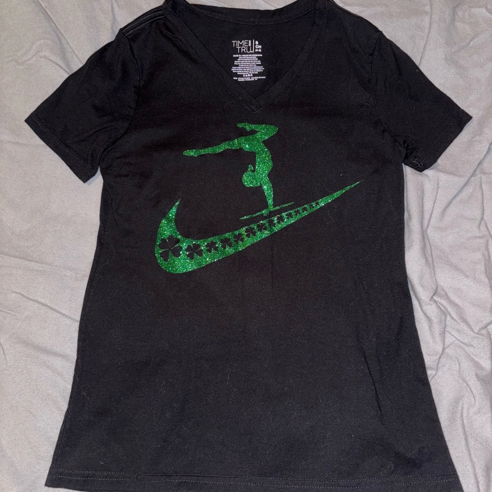size small black gymnastics t shirt with green sparkle shamrock design